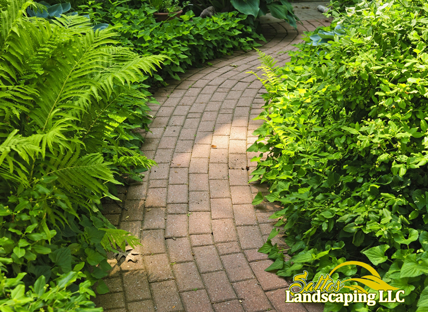 Brick garden walkway with vibrant flower borders.